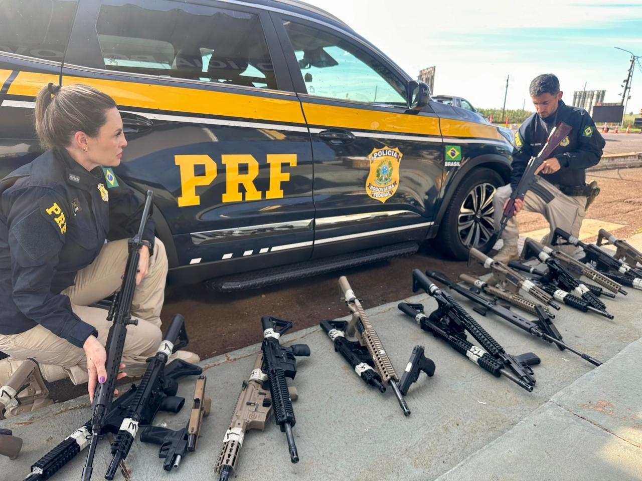 Agentes da Polícia Rodoviária Federal (PRF) exibem parte do arsenal apreendido na BR-277, em Foz do Iguaçu
