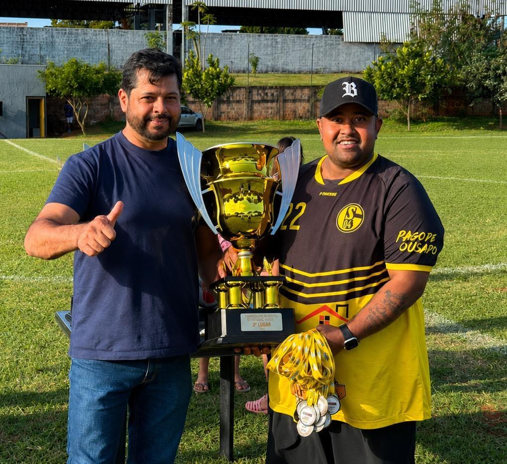 Vereador Diniz entrega o troféu de terceiro lugar à equipe Schalke durante a cerimônia de premiação do Campeonato Municipal de Futebol de Campo 2026, realizada após a grande final disputada neste domingo (19), em Terra Roxa