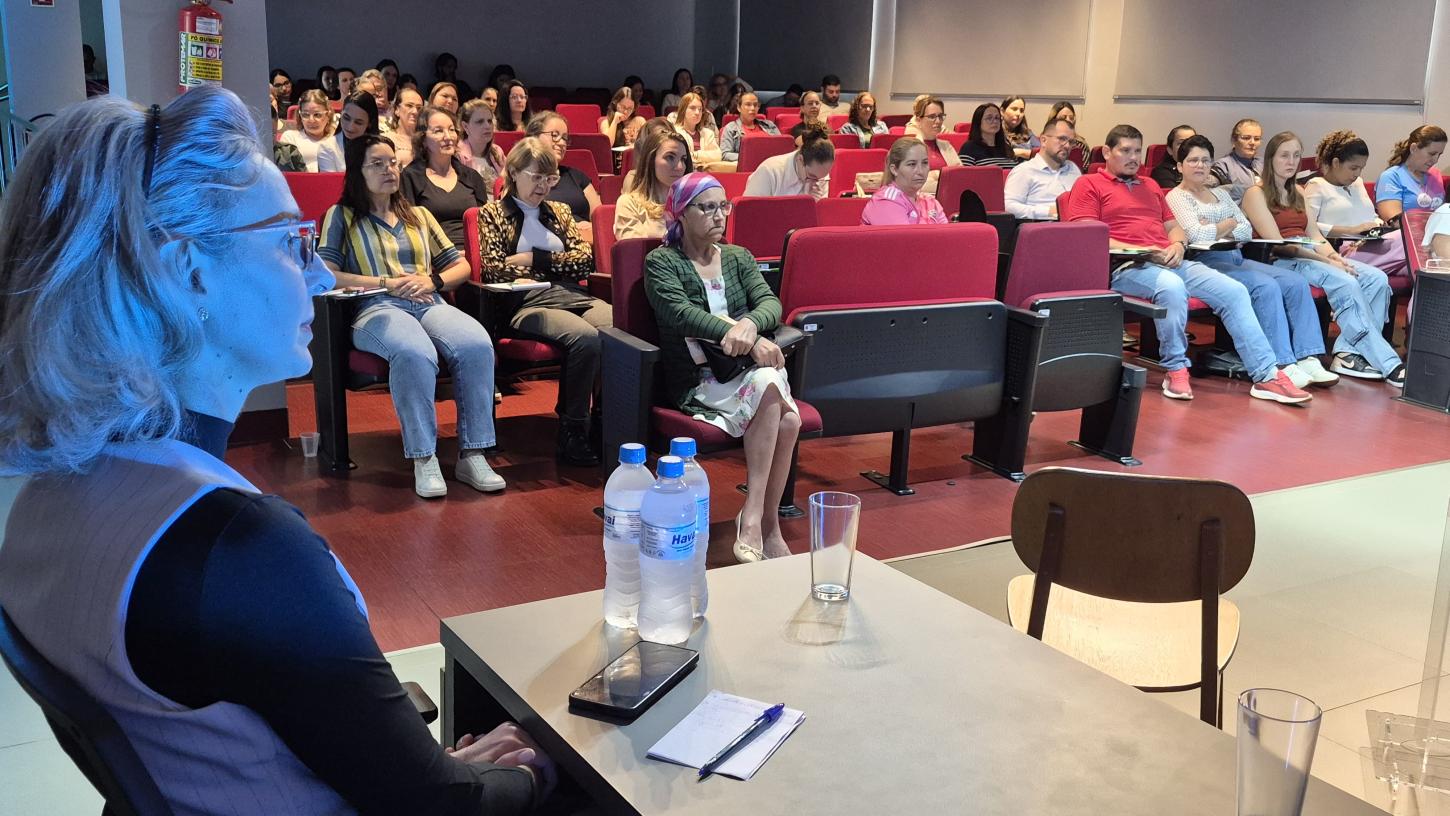 A vereadora Nissandra Karsten (PP), em primeiro plano, durante o Workshop Cuidados Paliativos, realizado por sua iniciativa na Câmara de Palotina. Ao fundo, o plenário lotado demonstra o interesse da comunidade pelo tema